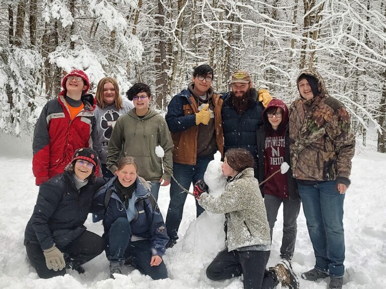 Photo of Anja Pfeffer & her students creating community in the snow
