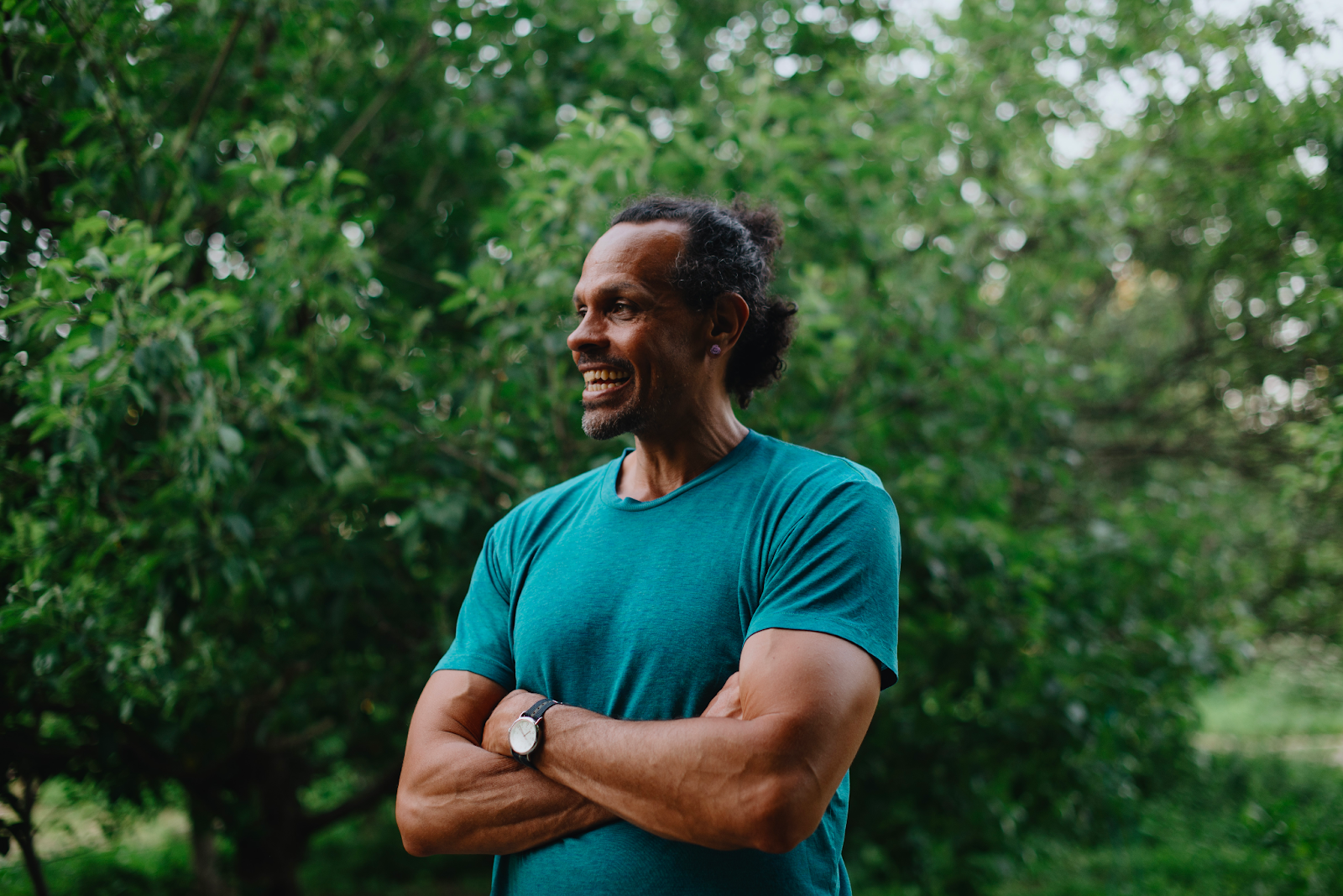 Photo of Ross Gay, poet & author, outside next to a tree