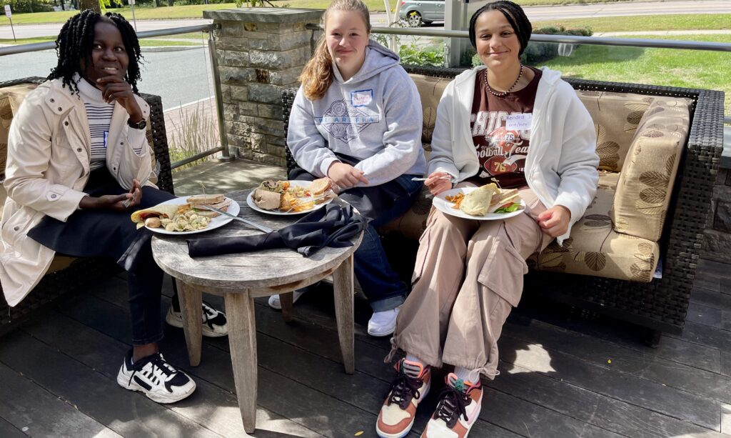 Photo of three students enjoying a meal outside where they discuss school change