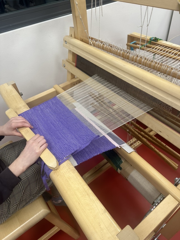 Photo of 6th Grade Student creating a loom tapestry during her free block